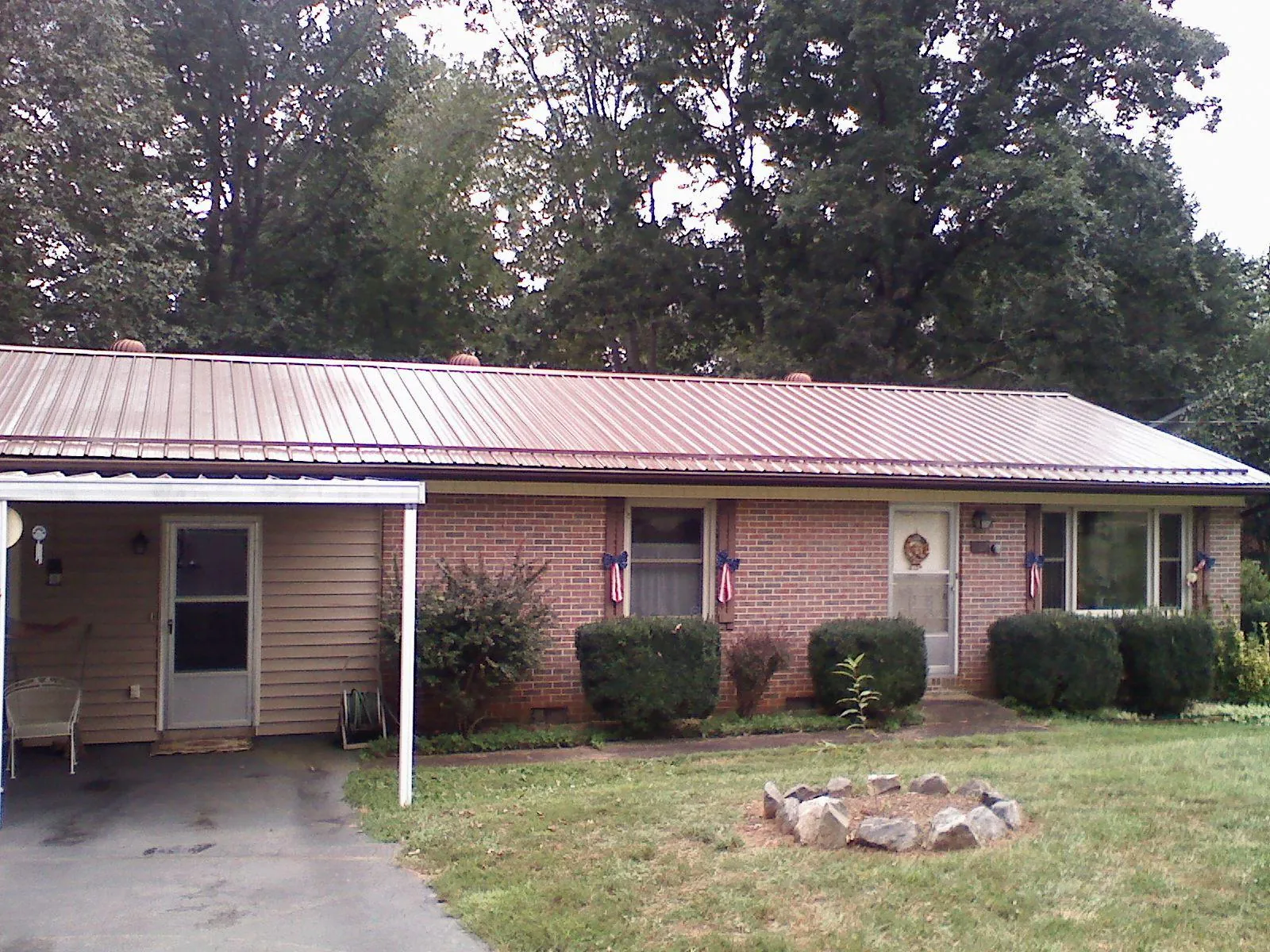 Bronze metal roof and carport on a brick ranch home — Roof Repair work by our crew in Harmon